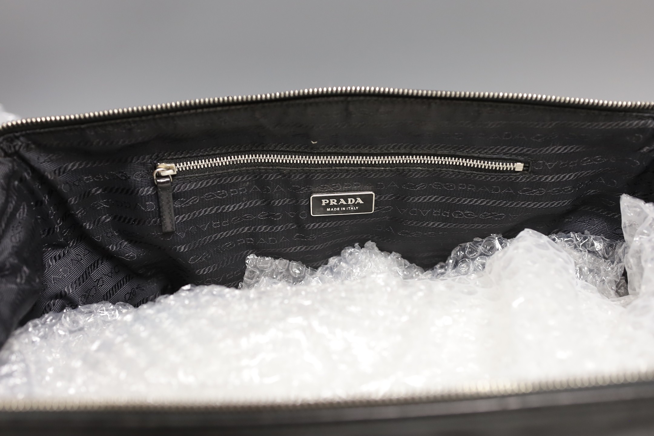 A Prada bowling bag style with zip up compartment